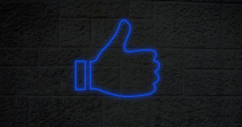 Neon Blue Thumbs Up Icon on Brick Wall for Social Media Concept
