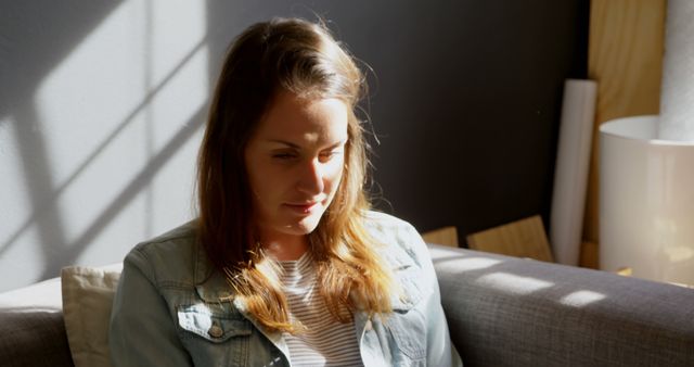 Woman in Natural Light Sitting on Sofa Contemplating - Download Free Stock Images Pikwizard.com