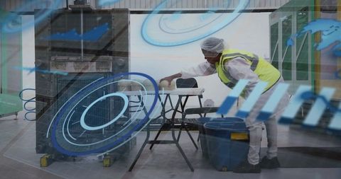Leaning worker placing container on sawhorse in industrial production plant
