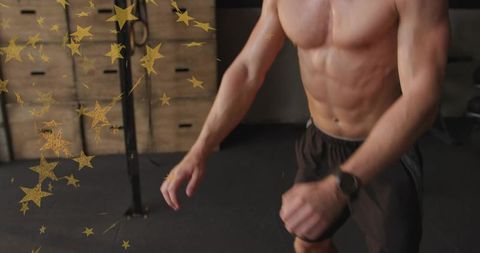Shirtless athlete training in gym with gold star overlay, plyo boxes, intense motion