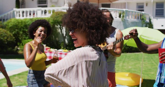 Diverse group of friends having fun and dancing at a pool party. Hanging out and relaxing outdoors in summer.