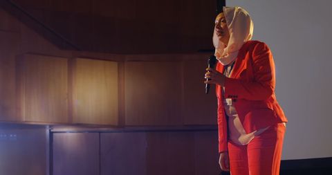 Businesswoman with Hijab Presenting in an Auditorium