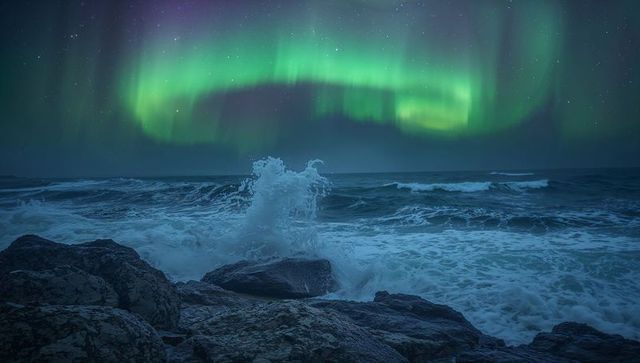Aurora Borealis Dancing Over Rocky Coastline with Crashing Waves and Sea Spray