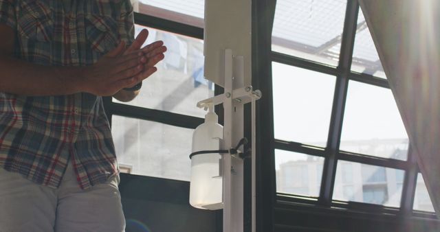 Person Sanitizing Hands with Dispenser in Sunlit Room - Download Free Stock Images Pikwizard.com