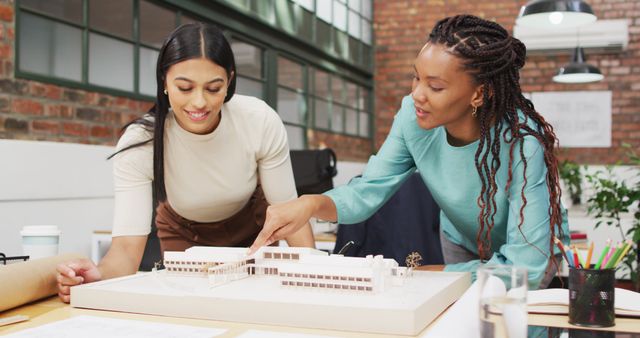 Female architects discussing architectural model in office - Download Free Stock Images Pikwizard.com