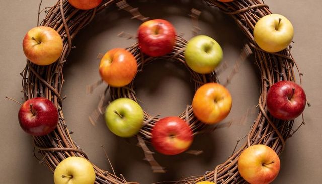 Rotating apples blurring on concentric grapevine wreaths for autumn decor