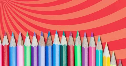 Colorful Wooden Pencils Lined in Rainbow Flatlay over Retro Red-Orange Swirl Background