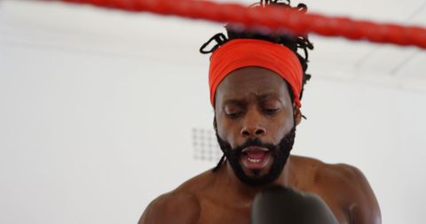 Focused Male Boxer Training in Boxing Ring with Intensity