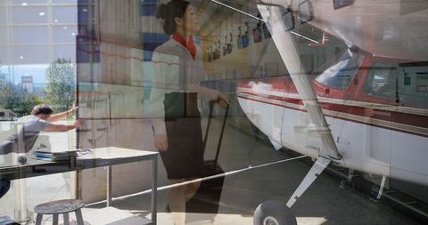 Modern Airport Lounge with Propeller Plane and Busy Staff