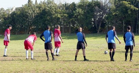 Male soccer team forming defensive wall for free kick