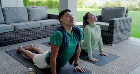 Outdoor Yoga Partners Engaged in Cobra Pose on Patio