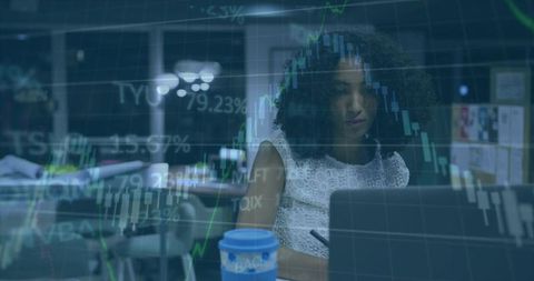 Female Professional Analyzing Financial Candlestick Charts on Laptop in Office Workspace