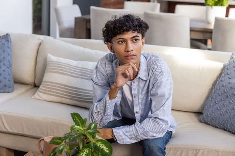 Thoughtful young man relaxing in modern living room
