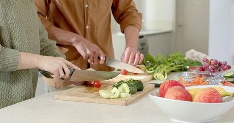 Couple Slicing Vegetables Together in Modern Kitchen