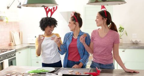 Diverse Female Friends Decorating Christmas Cookies in Rustic Kitchen
