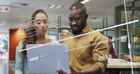 Collaborating on laptop with digital data overlays in modern open-plan coworking space