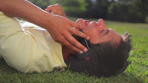 Man Smiling While Relaxing on Grass Talking on Phone