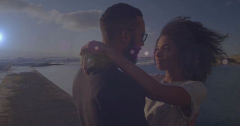 Romantic Embrace of Couple on Ocean Pier at Sunset
