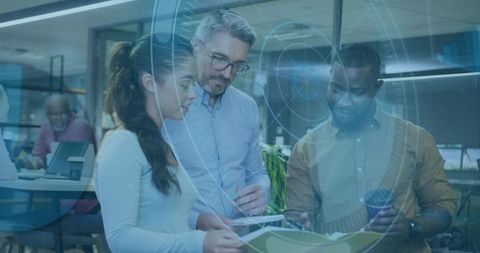 Diverse team collaborating on tablet and documents with futuristic HUD in modern office