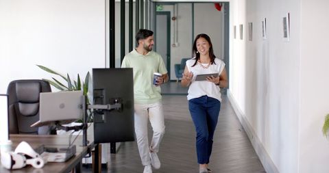 Colleagues Smiling and Chatting in Modern Office Corridor