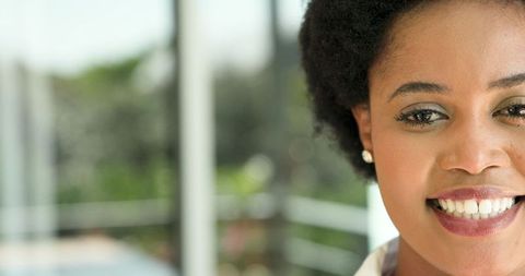 Smiling african american woman with pearl earrings on balcony