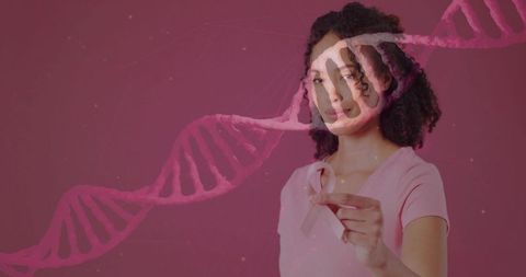 Woman holding pink ribbon with dna helix overlay breast cancer awareness concept