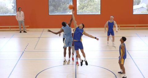 Athletes Competing for Basketball in Gymnasium Jumphstart