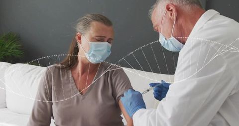 Clinician vaccinating patient at home wearing masks and protective gloves
