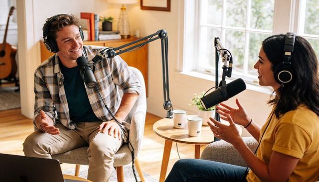 Recording two hosts chatting for home podcast with professional microphones and headphones