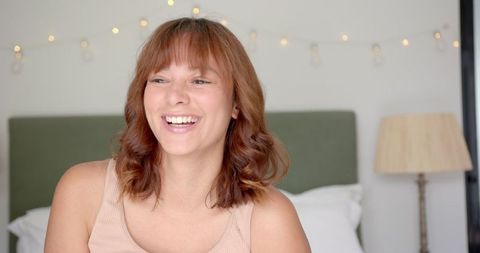 Cheerful Young Woman Relaxing at Home with Joyful Expression, Cozy Indoor Setting