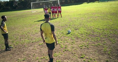 Diverse soccer team preparing free kick strategy outdoors