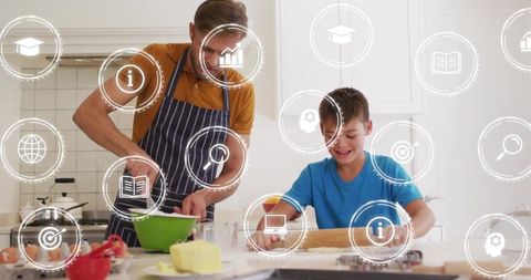 Father and son baking together in kitchen rolling dough and mixing ingredients for cookies