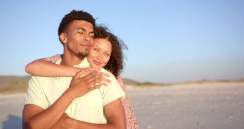 Romantic couple embracing on sandy beach