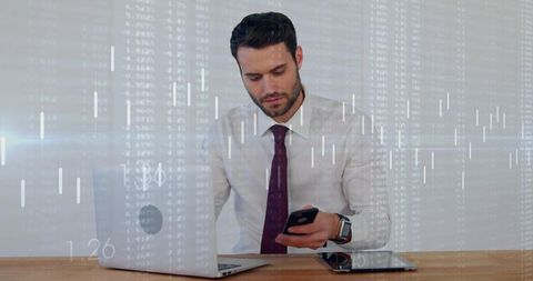 Businessman checking smartphone while monitoring stock market charts on laptop and tablet