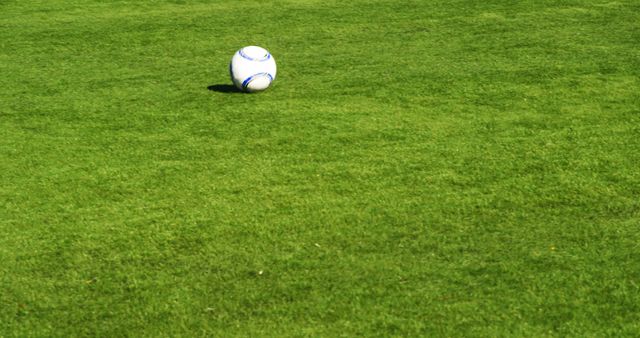 Soccer ball rests on a vibrant green field, with copy space. Outdoor sports scene captures the essence of a soccer match.