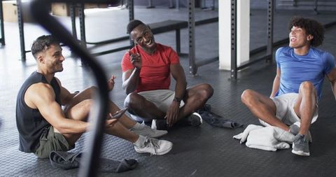 Group of diverse young men relaxing after workout in gym