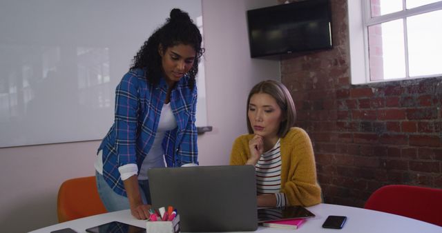 Two Professional Women Collaborating on Laptop in Modern Office - Download Free Stock Images Pikwizard.com