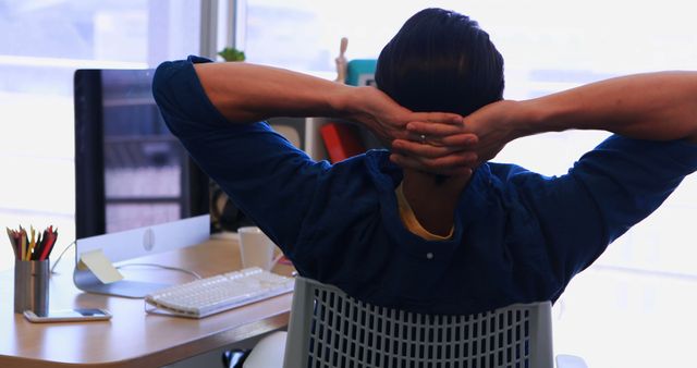 Man Relaxing with Hands Behind Head at Work Desk - Download Free Stock Images Pikwizard.com