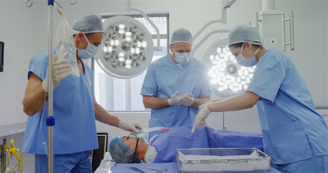 Surgery team discussing while operating a patient in an operating room at the hospital