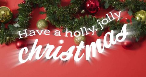 Holly jolly christmas greeting with evergreen garland and red gold baubles on red