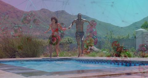 Energetic couple jumping into pool on sunny day