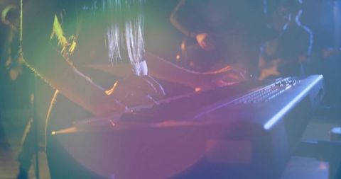 Live stage performance by keyboardist under concert lights