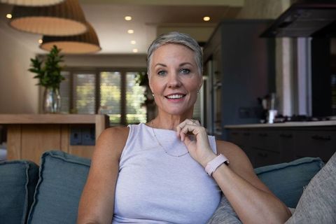 Senior Woman with Smartwatch Relaxing in Modern Living Room