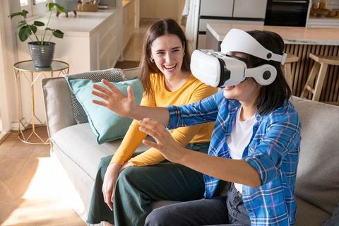 Diverse friends enjoying virtual reality experience in living room
