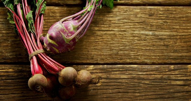 Photograph of fresh beetroot and kohlrabi placed on a rustic wooden table. This image evokes themes of organic farming, healthy eating, and farm-to-table cuisine. Ideal for use in food blogs, agricultural websites, health articles, and farm-to-table restaurant marketing materials.