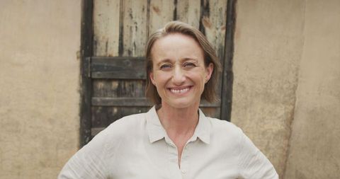 Smiling Senior Woman Outdoors with Hands on Waist