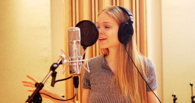 Beautiful woman singing in recording studio