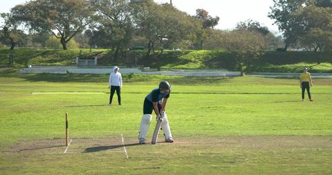 Teenage batsman preparing in cricket match on sunny field