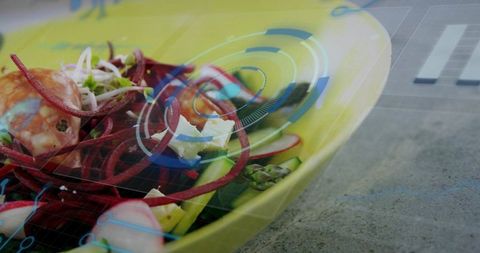 Yellow bowl featuring spiralized beet and vegetable salad macro with futuristic hud overlay