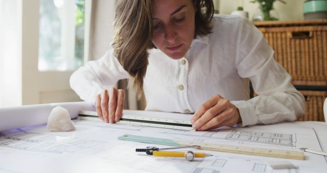Focused Female Architect Drafting Blueprints at Desk - Download Free Stock Images Pikwizard.com